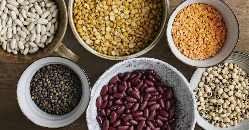 Uma variedade de alimentos saudáveis que ajudam a baixar o colesterol, incluindo frutas, legumes, nozes e peixes.