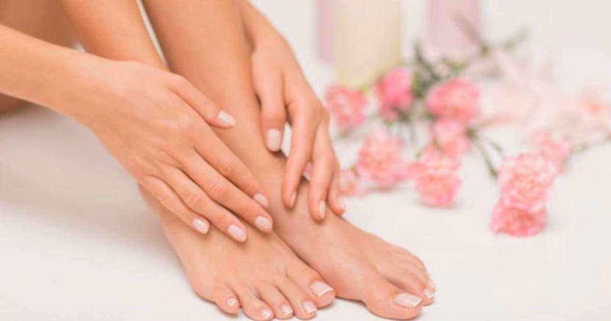 Uma bacia com água morna e ingredientes como lavanda e laranja para escalda-pés.