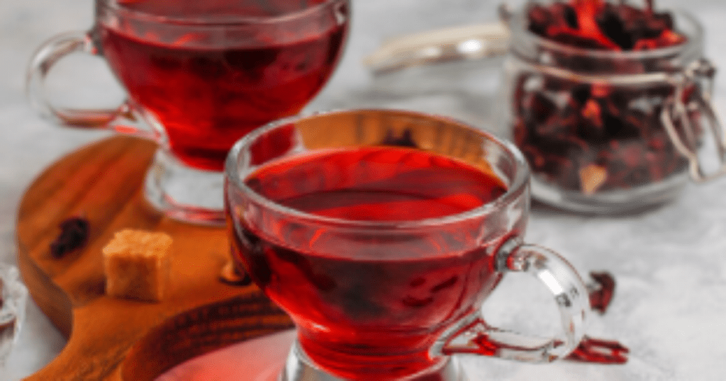 Xícara de chá de hibisco com flores secas ao fundo