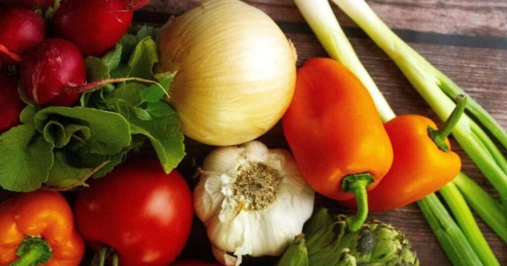 Uma seleção colorida de alimentos ricos em nutrientes para fortalecer a imunidade, incluindo laranjas, limões, kiwis, acerolas, tomates, peixes, ovos, nozes e sementes.