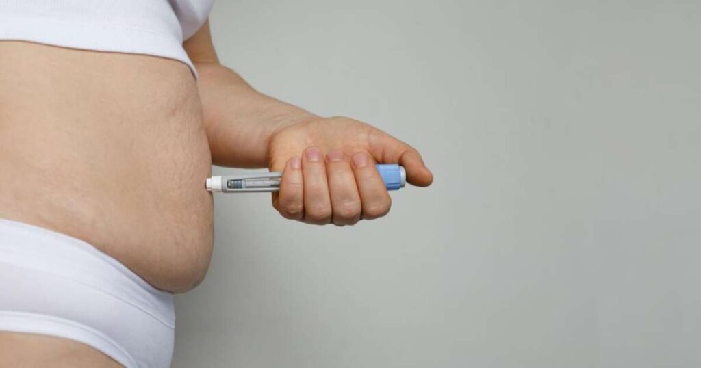 Caneta emagrecedora sobre uma mesa com frutas e legumes ao fundo