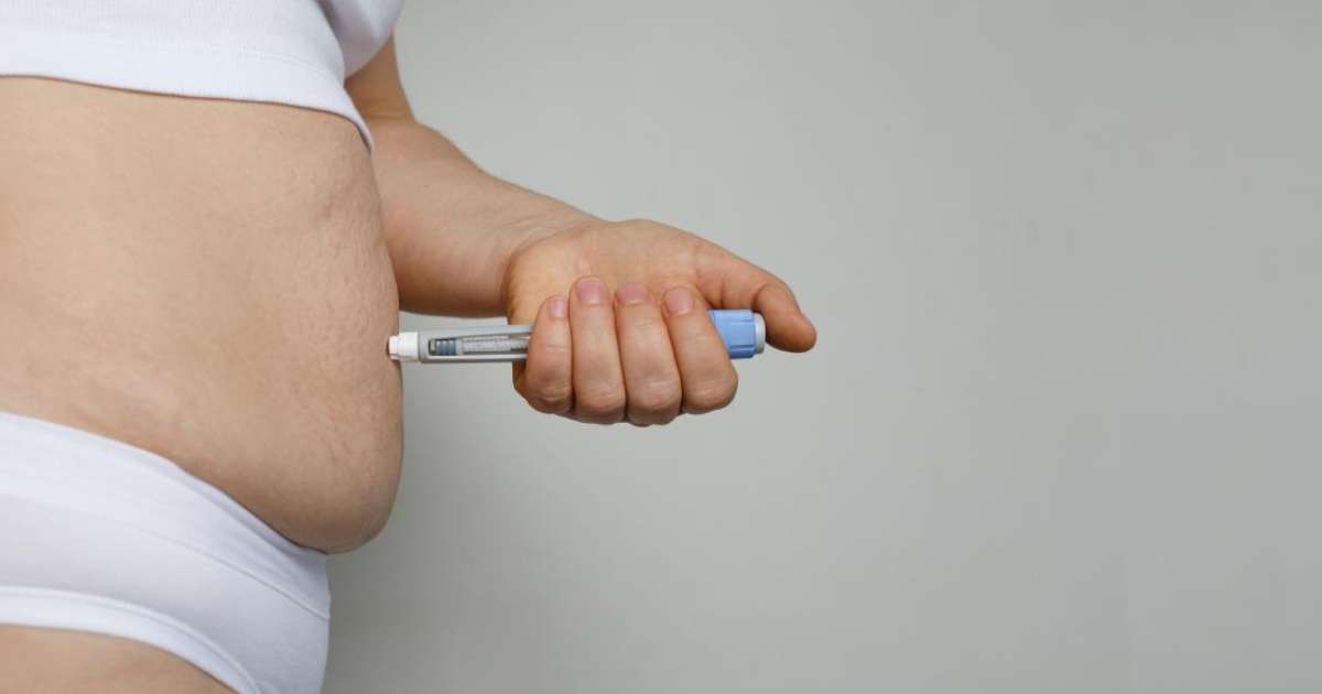 Caneta emagrecedora sobre uma mesa com frutas e legumes ao fundo