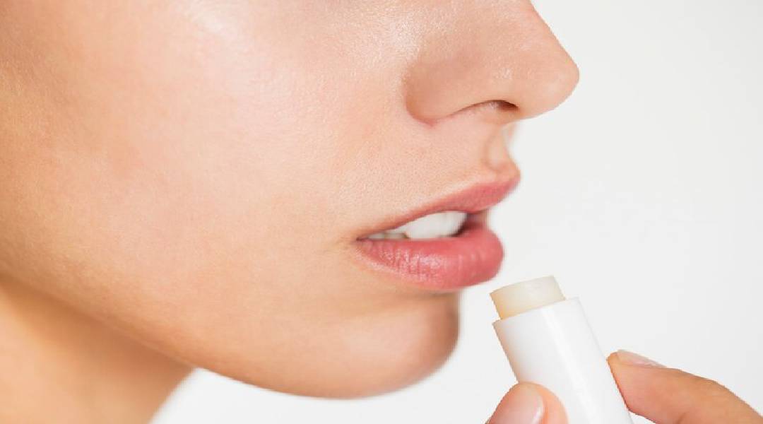 Hidratante labial em um fundo neutro, ilustrando a importância dos cuidados labiais.