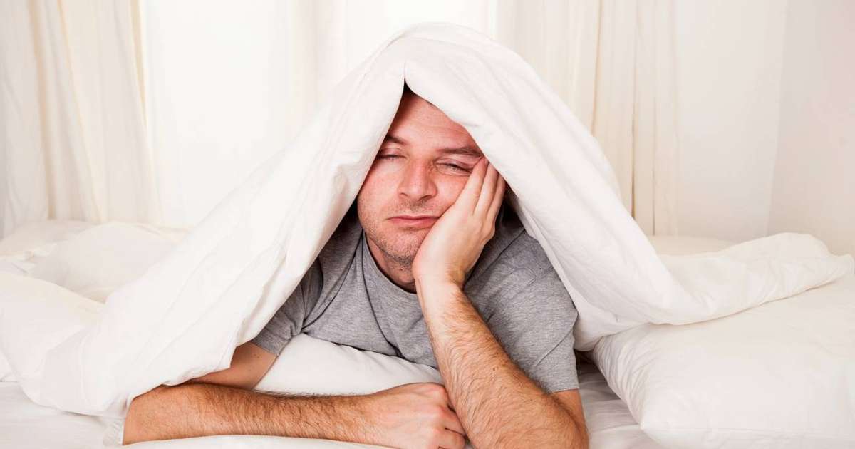 Pessoa acordando no meio da noite, representando as causas e soluções para acordar de madrugada.