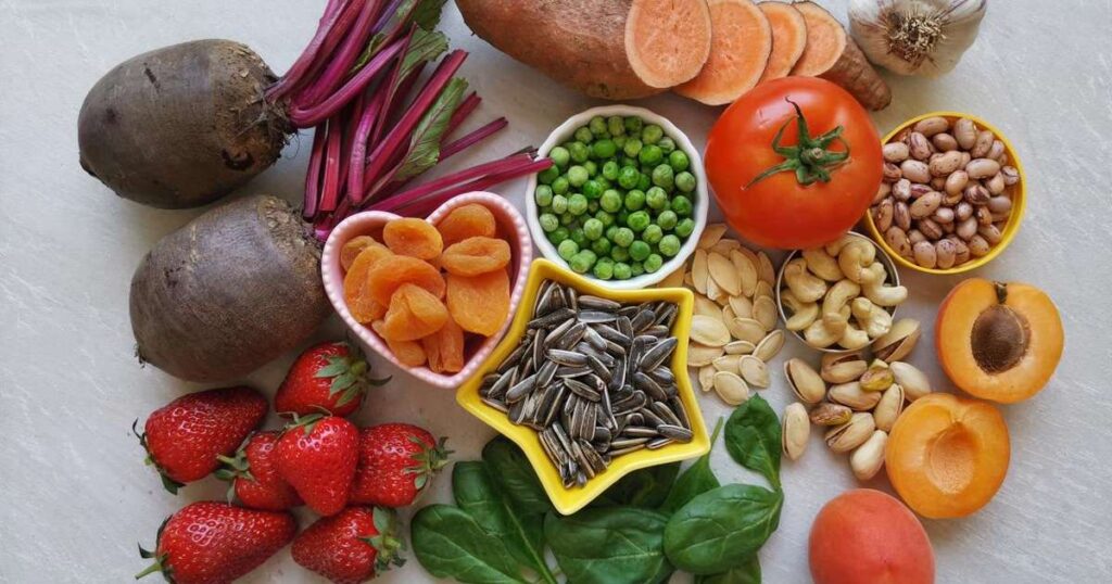 Uma variedade de alimentos ricos em ferro como fígado de frango, espinafre e sementes de abóbora em uma mesa saudável