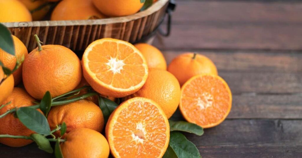 Fatias de laranja em cima de uma mesa, destacando os benefícios da fruta para a saúde.
